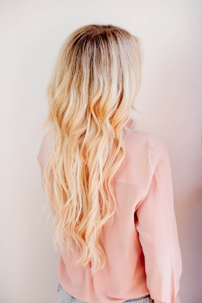 Woman has long blonde extensions.