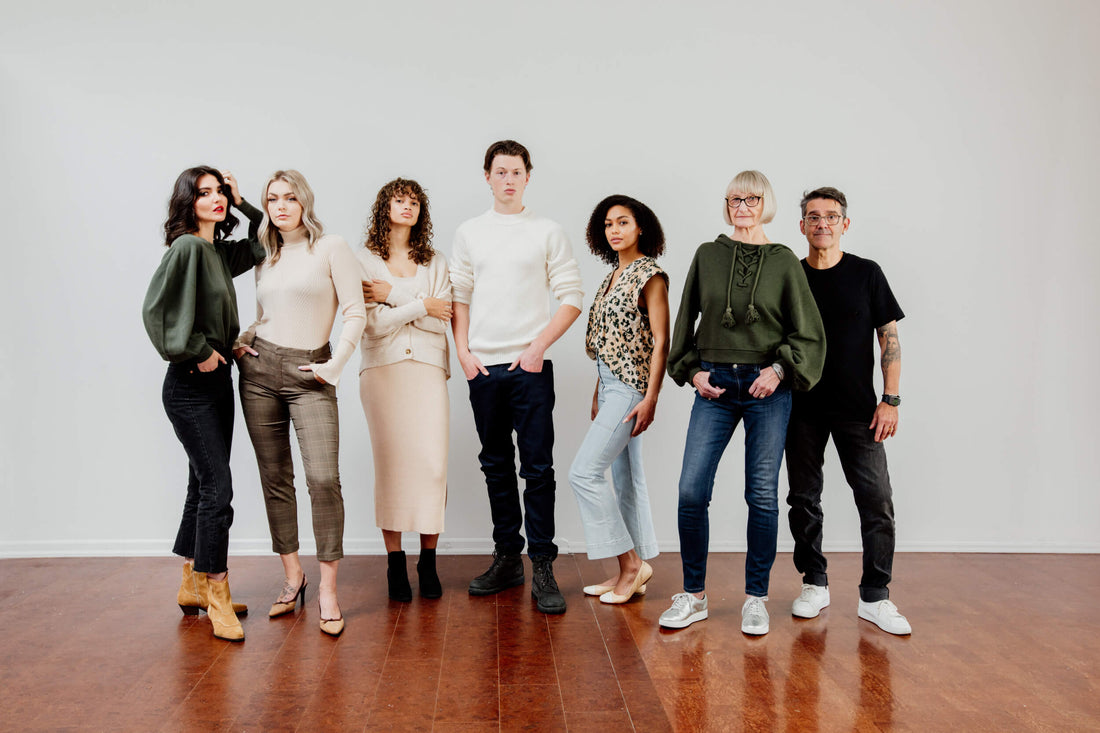A group of people with newly styled hair in stylish clothes are standing.