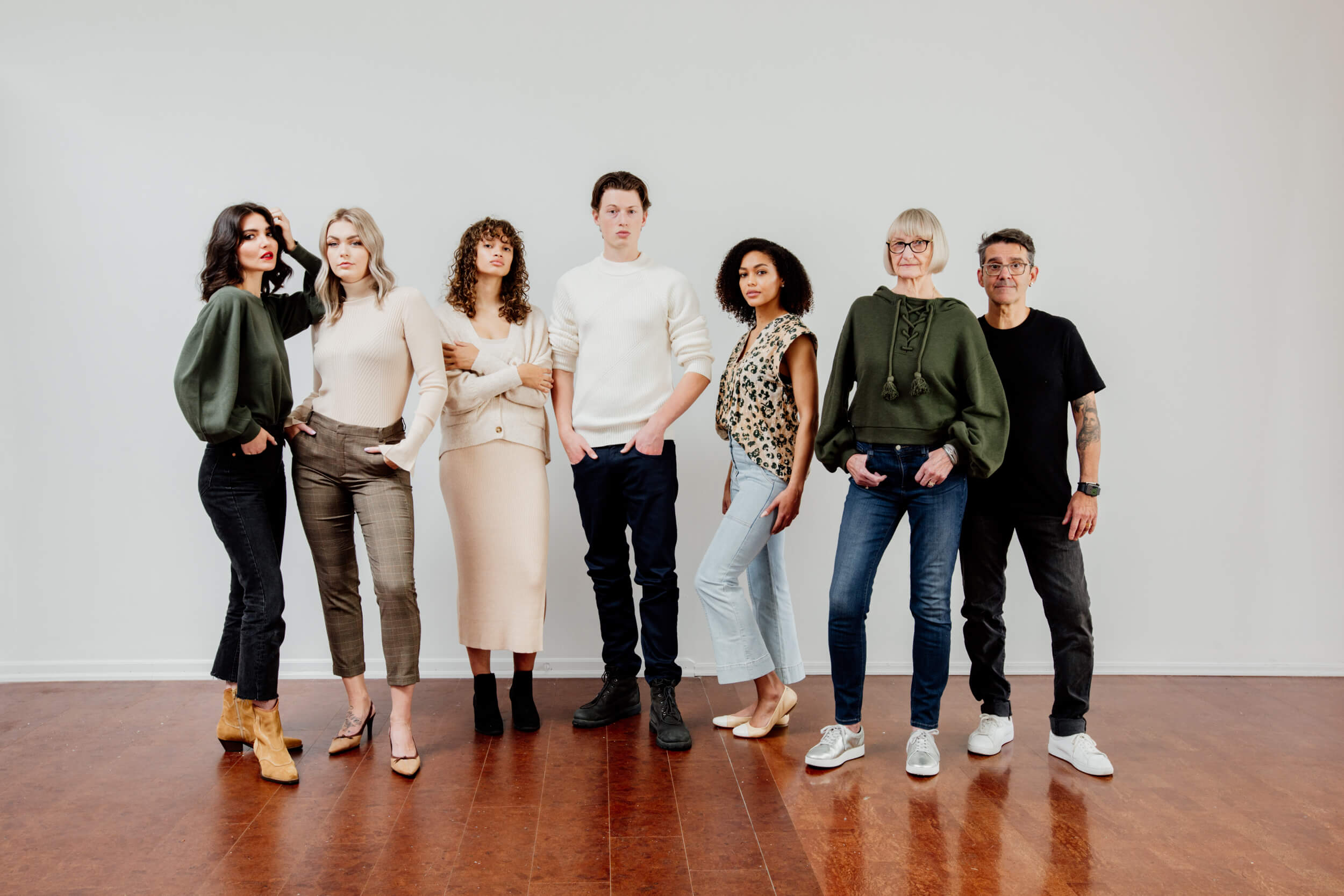 A group of people with newly styled hair in stylish clothes are standing.