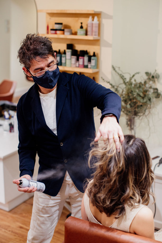 stylist spraying the shampoo on a client
