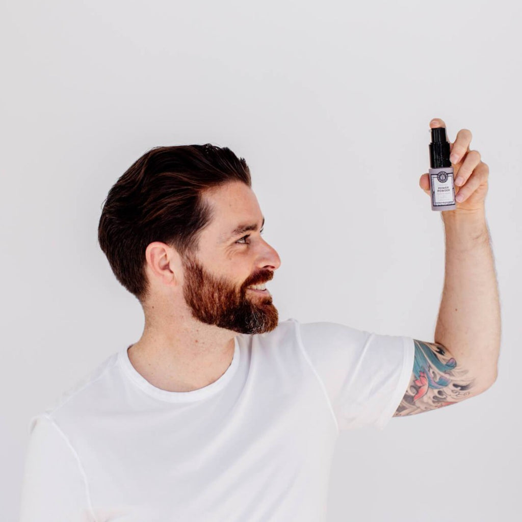man is holding a volumizing powder for his hair